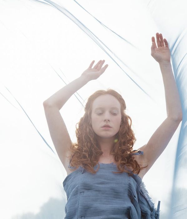 Person meditating peacefully outdoors with soft natural light around them.